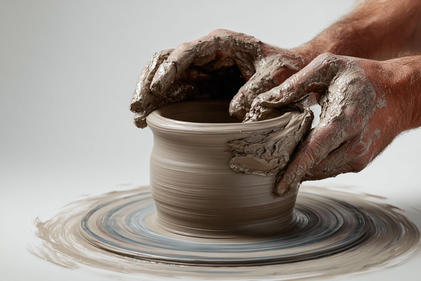 Hands shaping clay on a potter's wheel